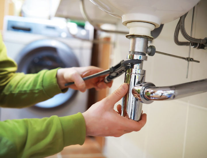Technician cleaning laundry sink drain